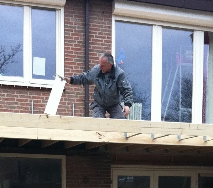 Peter van Egmond aan het werk op het dak van een aanbouw